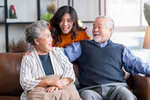 Free photo happiness asian family candid of daughter hug grandparent mother farther senior elder cozy relax on sofa couch surprise visiting in living room at hometogether hug cheerful asian family at home